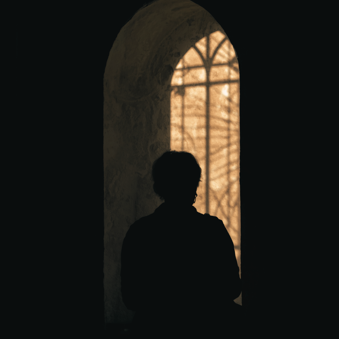 Figure standing in window light