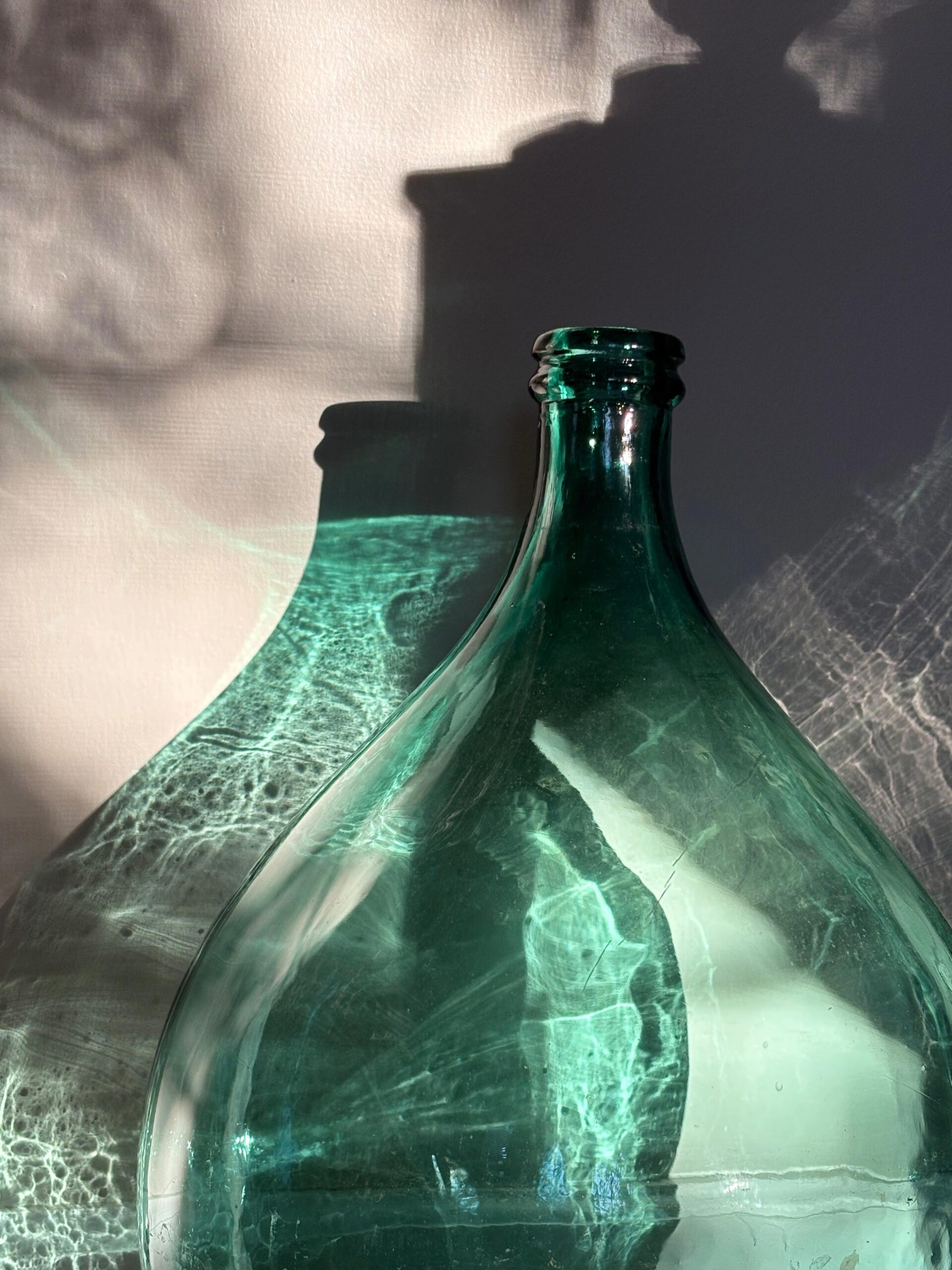 Green glass vessel illuminated by sunlight and shadow