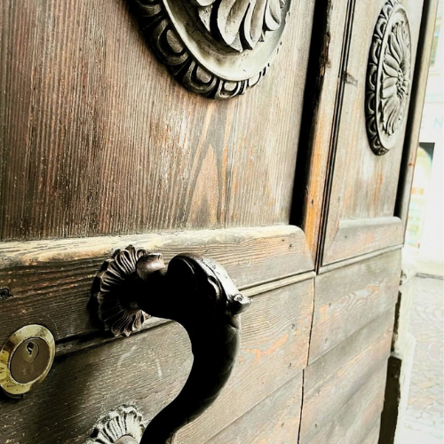 Close view of an old wooden door and iron handle