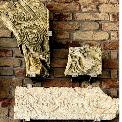 Carved architectural fragments mounted against brick