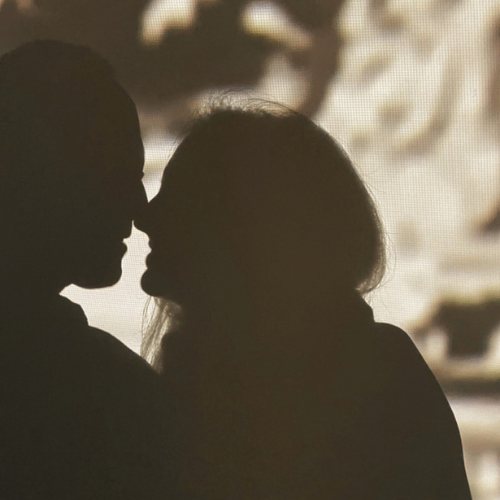 Silhouetted couple facing one another